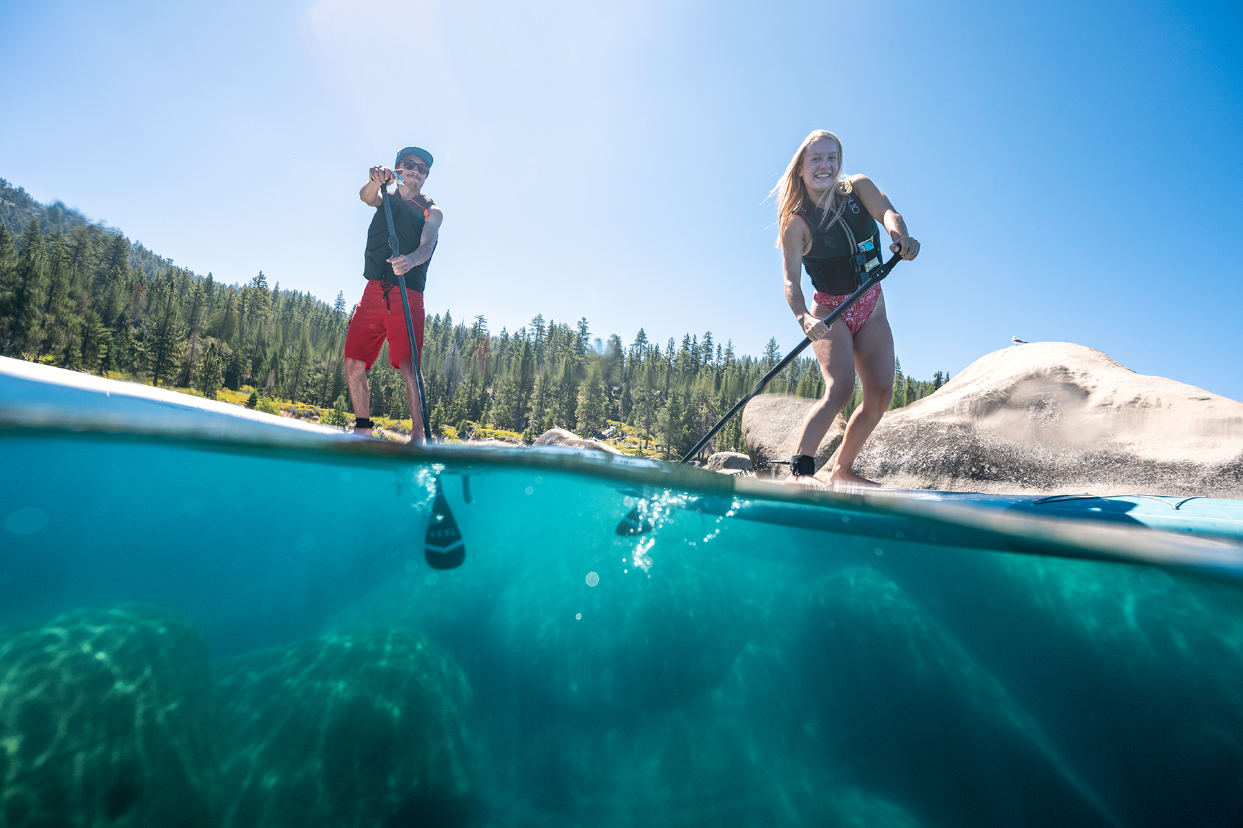 two people paddleboarding Tahoe on a summer day